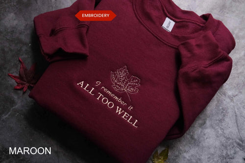 A burgundy sweatshirt with a white embroidered leaf design and the text "I remember it all too well" printed on it.