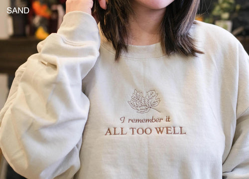 A person wearing a white sweatshirt with the text "I remember it all too well" printed on it.