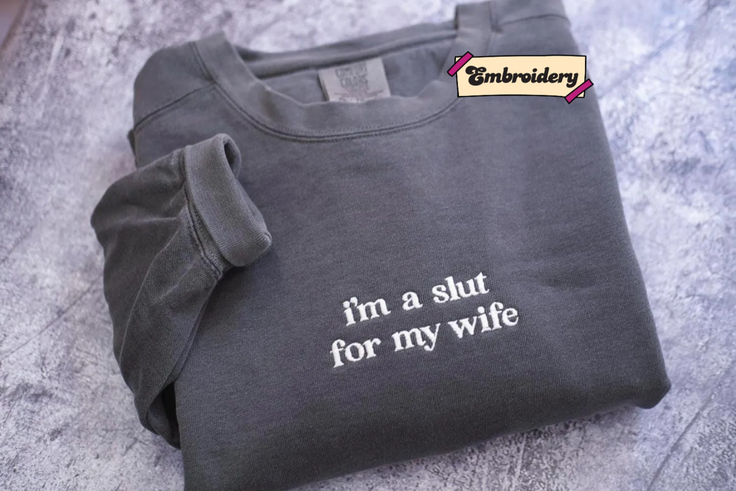 A gray sweatshirt with the text "i'm a shut for my wife" embroidered on it.
